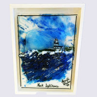 "Handcrafted fused glass art of Hook Lighthouse, showcasing vibrant ocean waves, a stormy blue sky, and intricate details in a custom white coloured wood frame."